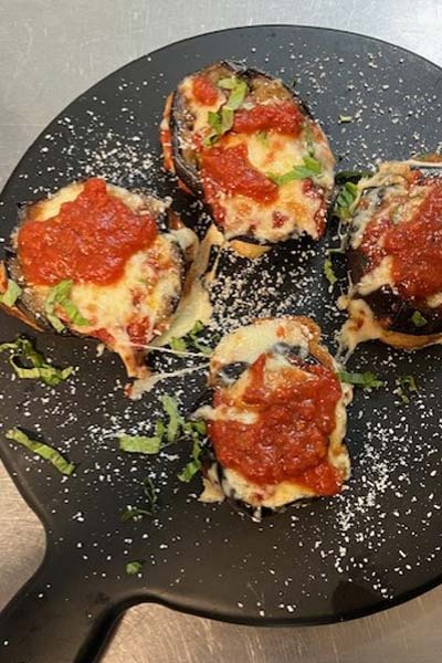 Four eggplant slices topped with melted cheese at an Italian Restaurant in Richmond VA.